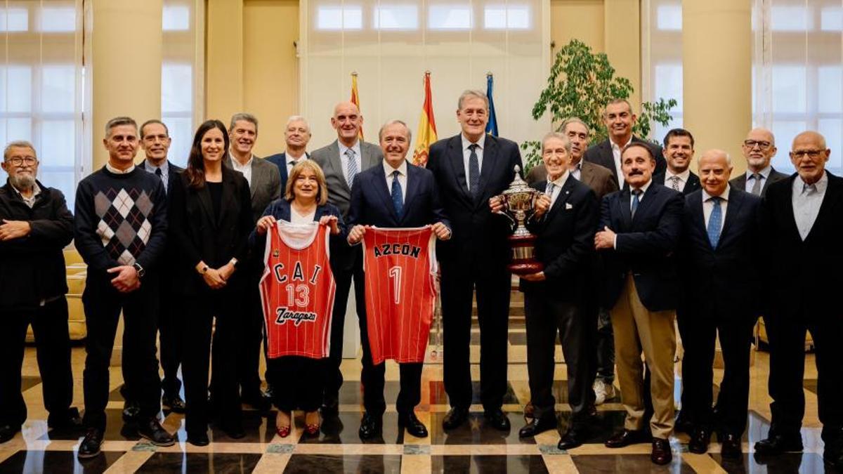 Jorge Azcón y Tomasa Hernández posan con sus camisetas del CAI Zaragoza y con parte de la plantilla que consiguió la Copa del Rey del 1983 en la sede de la DGA.