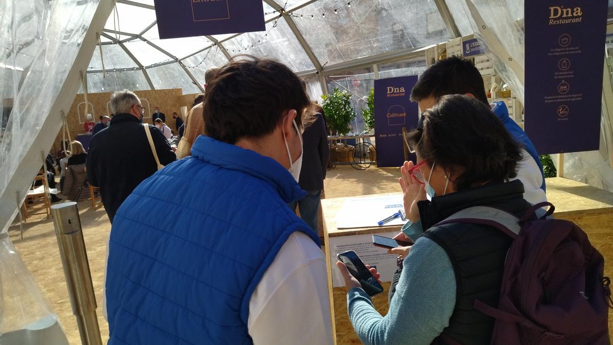 Una de las asistentes muestra el pasaporte covid para acceder al iglú del escenario &quot;compartint&quot;