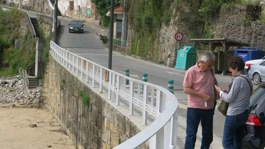 Al fondo, la escalera en la playa de El Escanu.