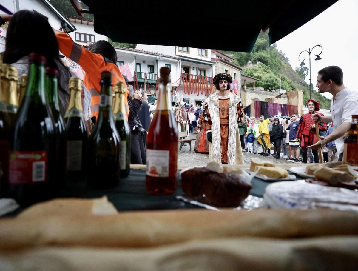 Carlos V, ya desembarcado, es invitado a examinar los productos de un puesto del mercado de Tazones. | Irma Collín