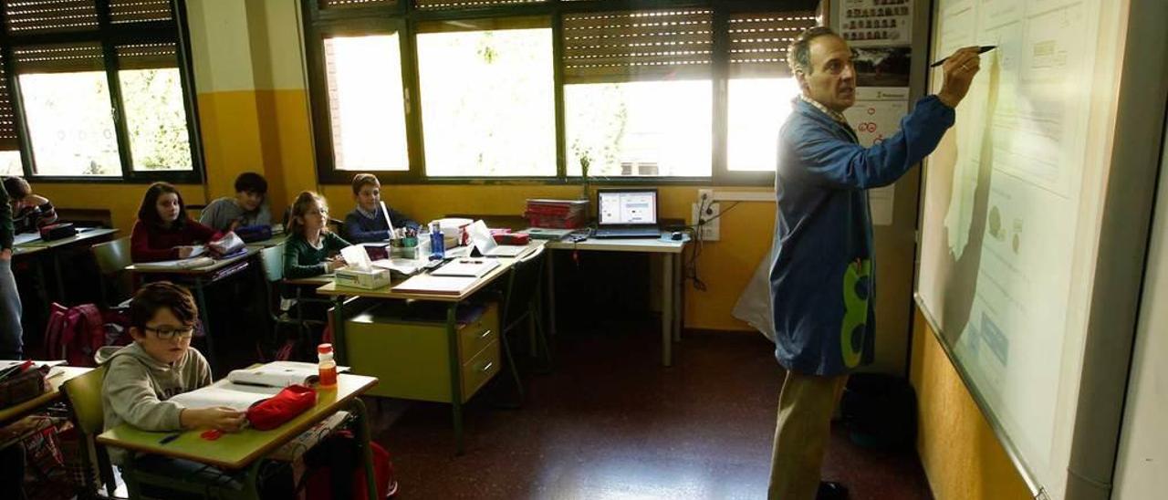 El profesor Javier Morán emplea una pizarra digital para dar Matemáticas a niños de Primaria.