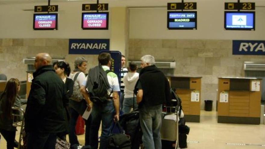 Diversos passatgers esperen per facturar les maletes en un vol a Madrid