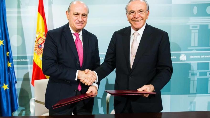 El ministro de Interior, Jorge Fernández, firma el acuerdo con el presidente de la Caixa.