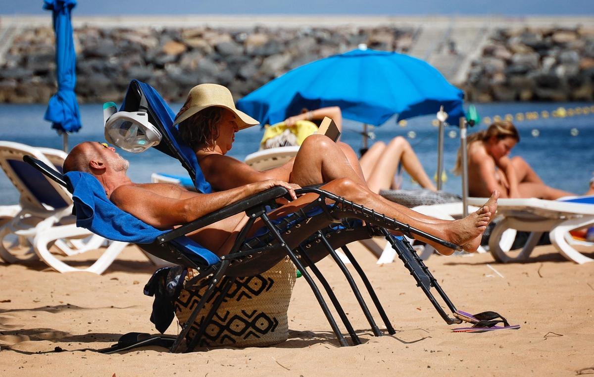 Dos personas disfrutan del descanso en la playa.