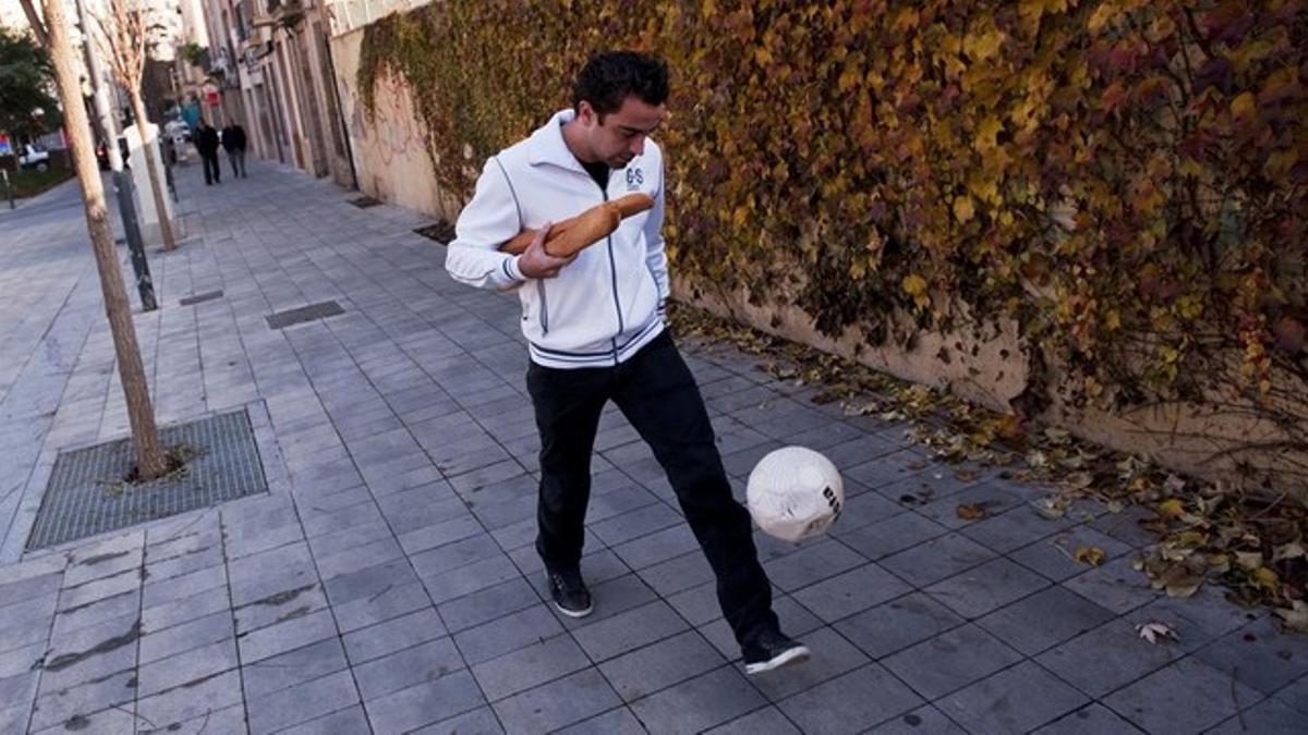 El jugador del Barça, Xavi Hernández, recuperando recuerdos de su infancia cuando se entretenía jugando con el balón en la plaza del Progress en Terrasa en lugar de ir a buscar el pan para casa al mediodía