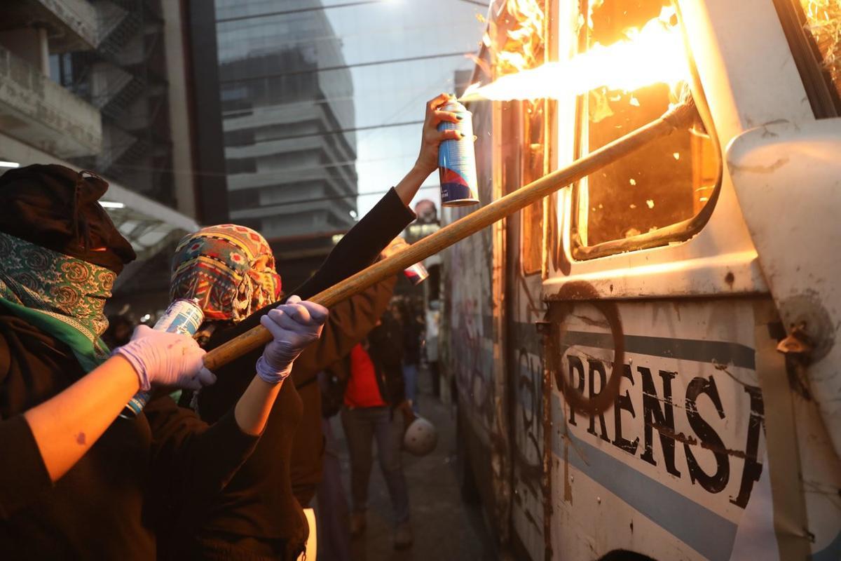 AME2625. CIUDAD DE MÉXICO (MÉXICO), 14/02/2020.- Mujeres protestan frente al periódico la prensa hoy viernes, en Ciudad de México. Cientos de activistas mexicanas que marcharon este viernes en la capital contra la violencia de género, prendieron fuego a cuatro vehículos de un periódico como un represalia a los medios que difundieron imágenes del feminicidio de Ingrid Escamilla. EFE/Sáshenka Gutiérrez