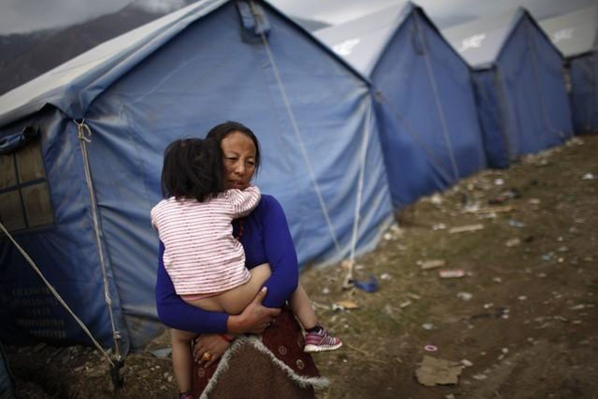 Una dona tibetana sosté la seva filla a l’exterior de la tenda de campanya en un campament improvisat per a les persones afectades pel terratrèmol de 2010 a Yushu, Xina, dos anys després del terratrèmol.