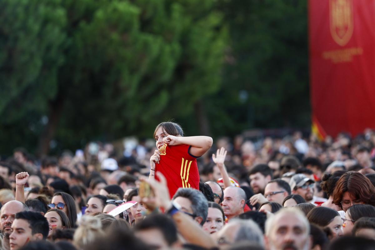 Una joven muestra el escudo de la selección española campeona del mundo.