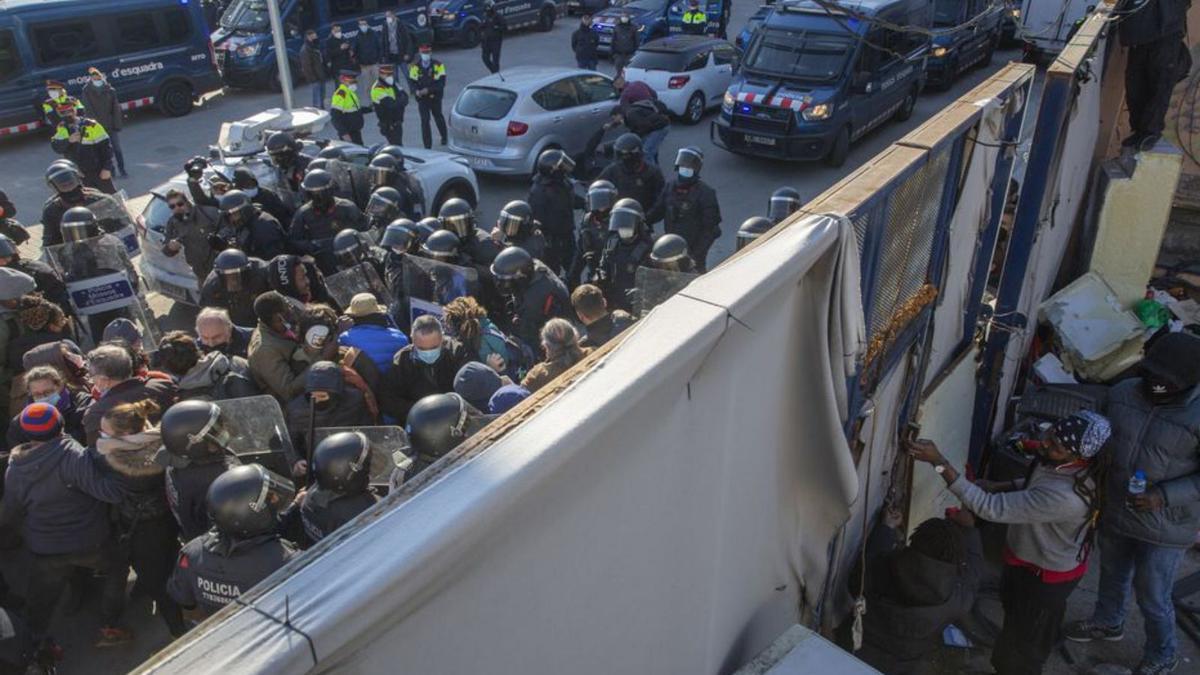 Els Mossos carregant per entrar a la nau. | ELISENDA PONS