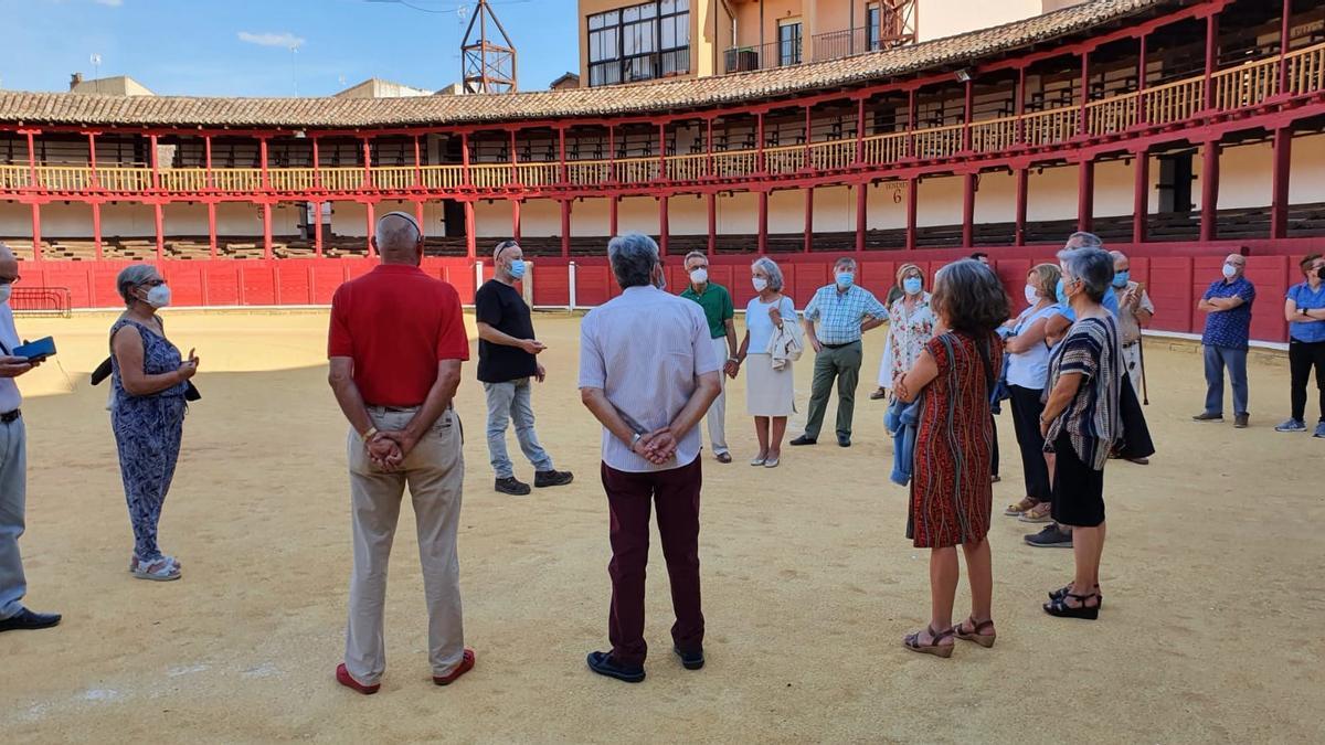 Participantes en la visita previa al concierto admiran la plaza de toros de la ciudad