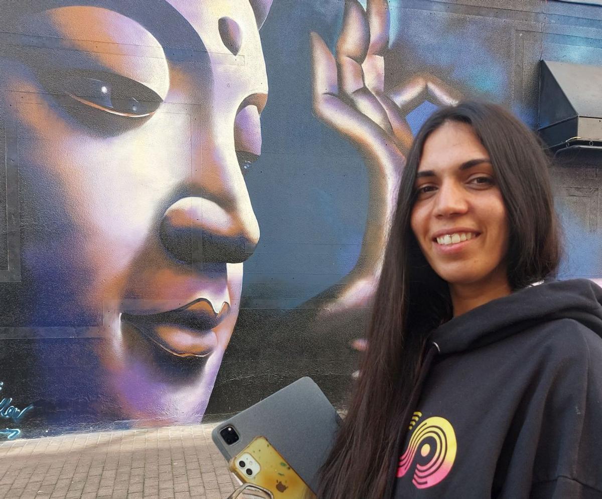 Yovana Fandiño ante “El Buda” que pintó en la fachada de un local de hostelería de Cangas.   | // S.Á. 