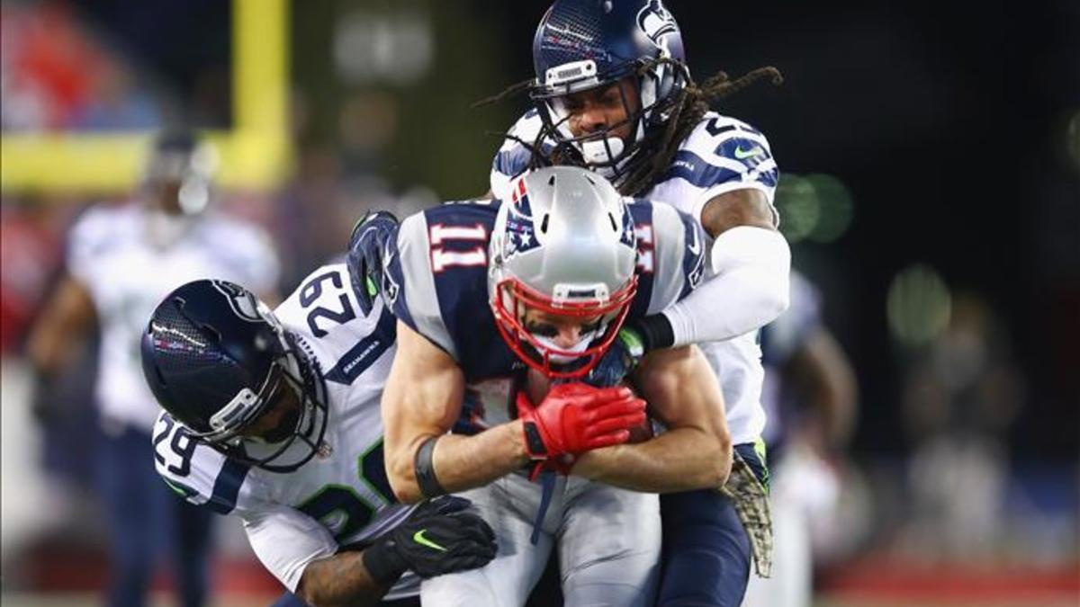 Julian Edelman (11) de los Patriots intenta superar a Earl Thomas (29) y Richard Sherman (25) de los Seahawks