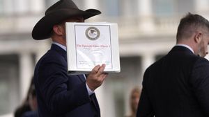 Jack Posobiec hold up a binder with a cover titled The Epstein Files: Phase 1 at the White House, Thursday, Feb. 27, 2025, in Washington. (AP Photo/Evan Vucci)