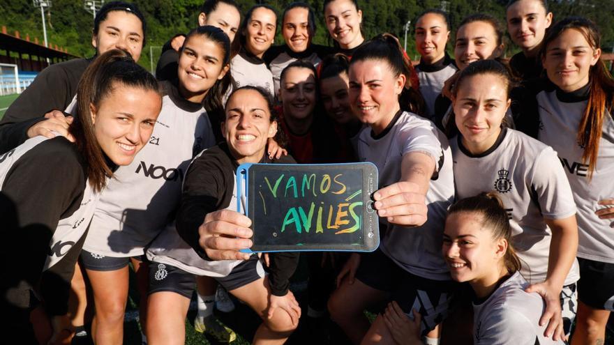 Las jugadoras del Femenino, con un cartel apoyando al Avilés. | MARA VILLAMUZA