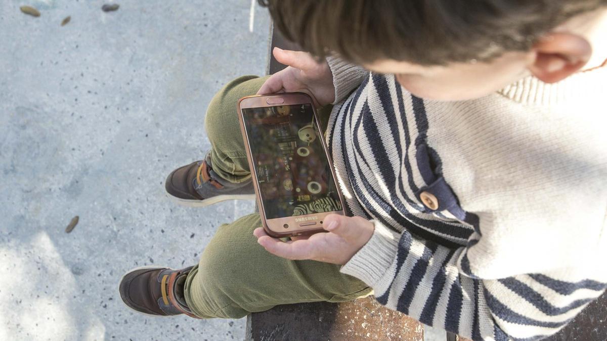 Un niño viendo dibujos en un teléfono móvil