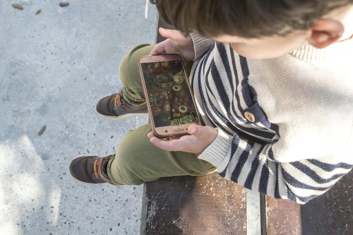 Un niño viendo dibujos en un teléfono móvil