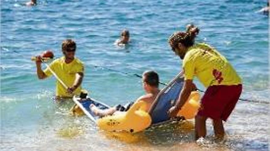 Dos socorristes de Lloret ajuden una persona a accedir a la platja.
