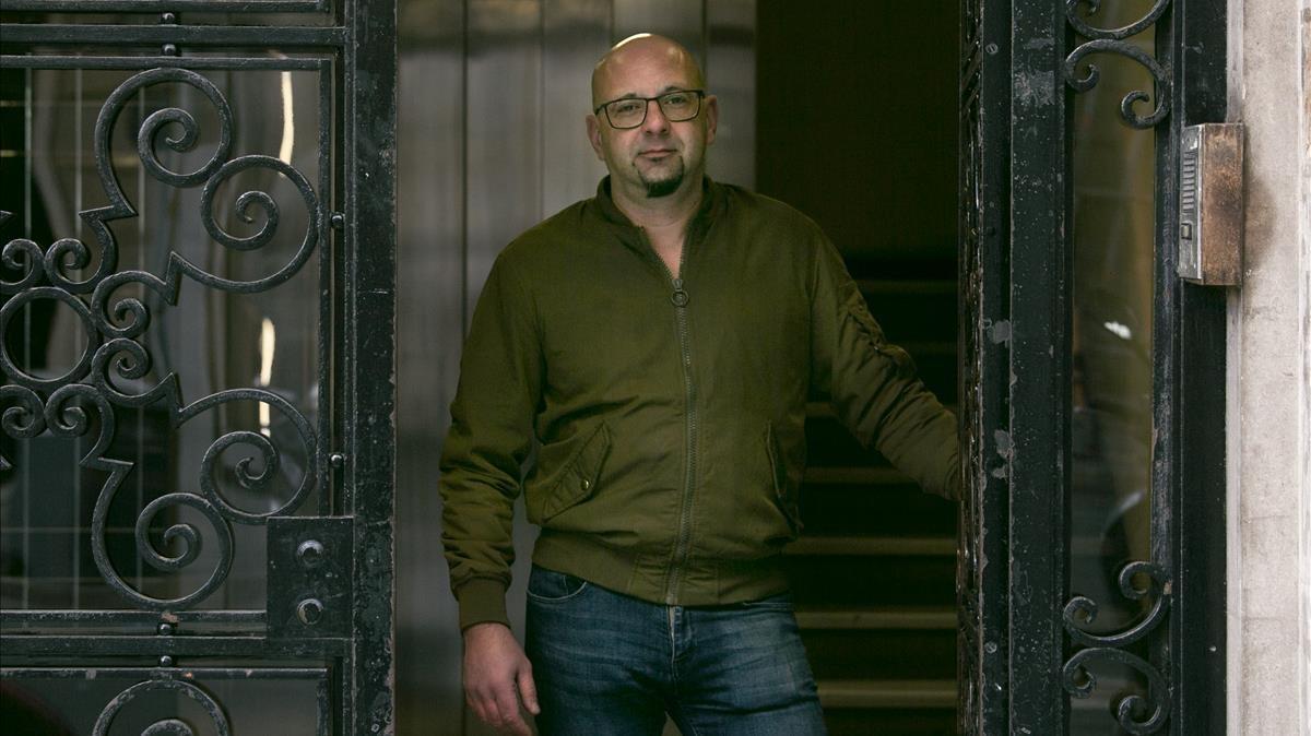 Cesar Mena, portero del número 288 de la calle de Provença, frente a la puerta del edificio.