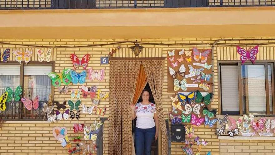 María del Carmen Díaz en la puerta de su casa, decorada con mariposas con los colores del bordado carbajalino.