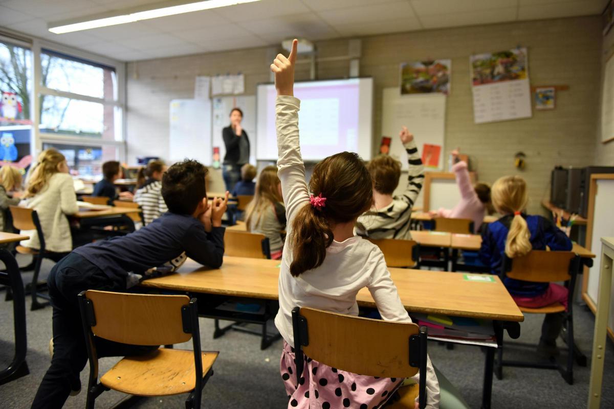 Una niña levanta la mano en clase, en una imagen de archivo.