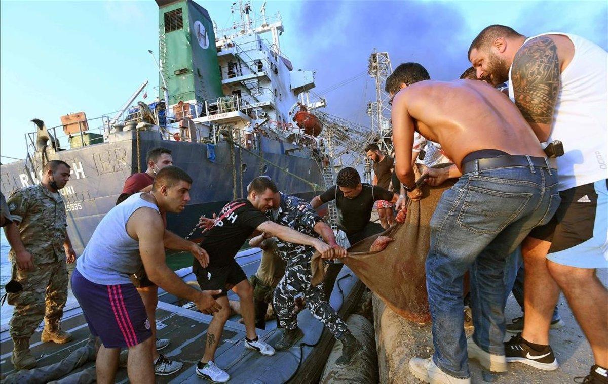 Un hombre herido es evacuado de un barco, tras la explosión en el puerto de Beirut.