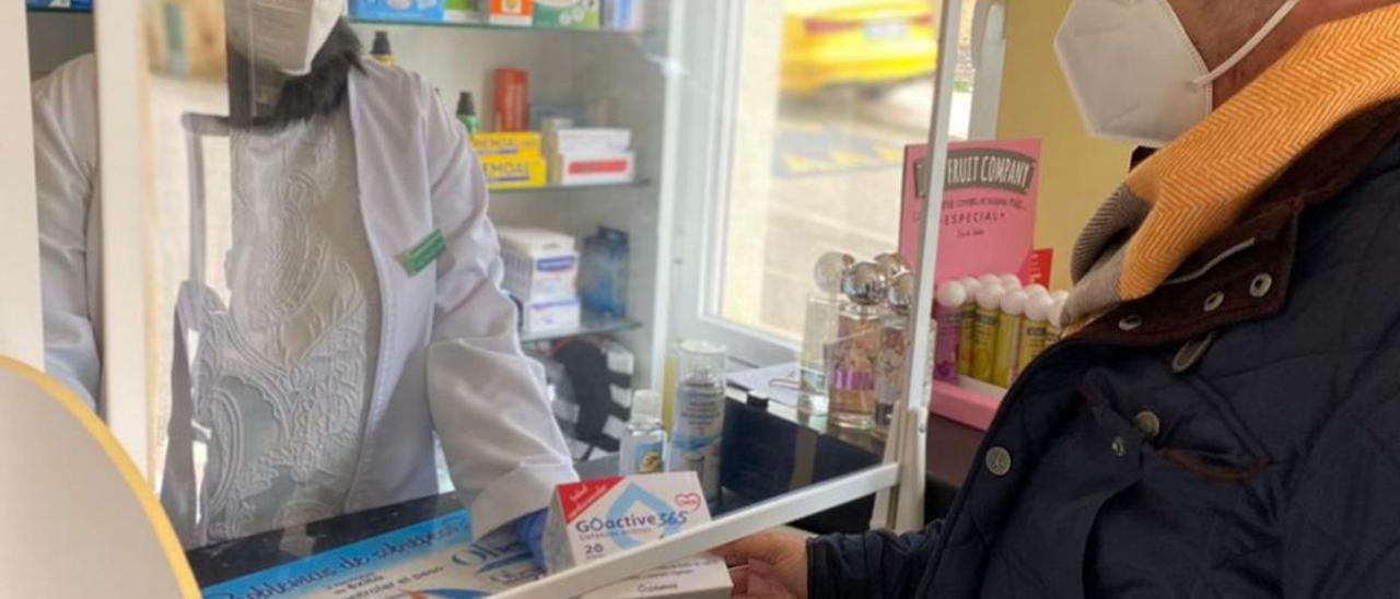 Un hombre adquiere un producto en una farmacia. |