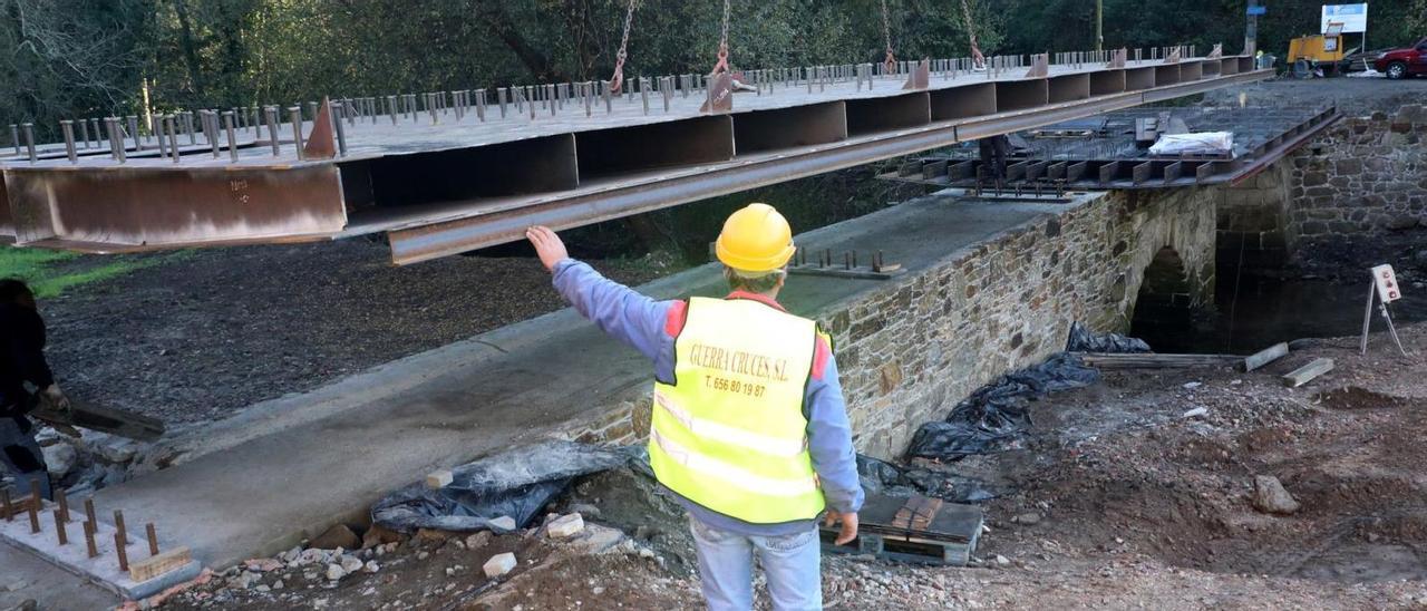 Trabajadores de Guerra Cruces SL colocan la estructura metálica que refuerza el puente de Vidán, en Santiago.  | // XOÁN ÁLVAREZ