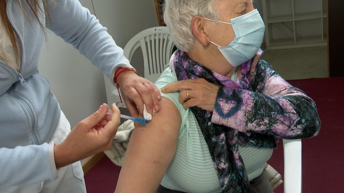 Una mujer se vacuna contra la covid en Alzira