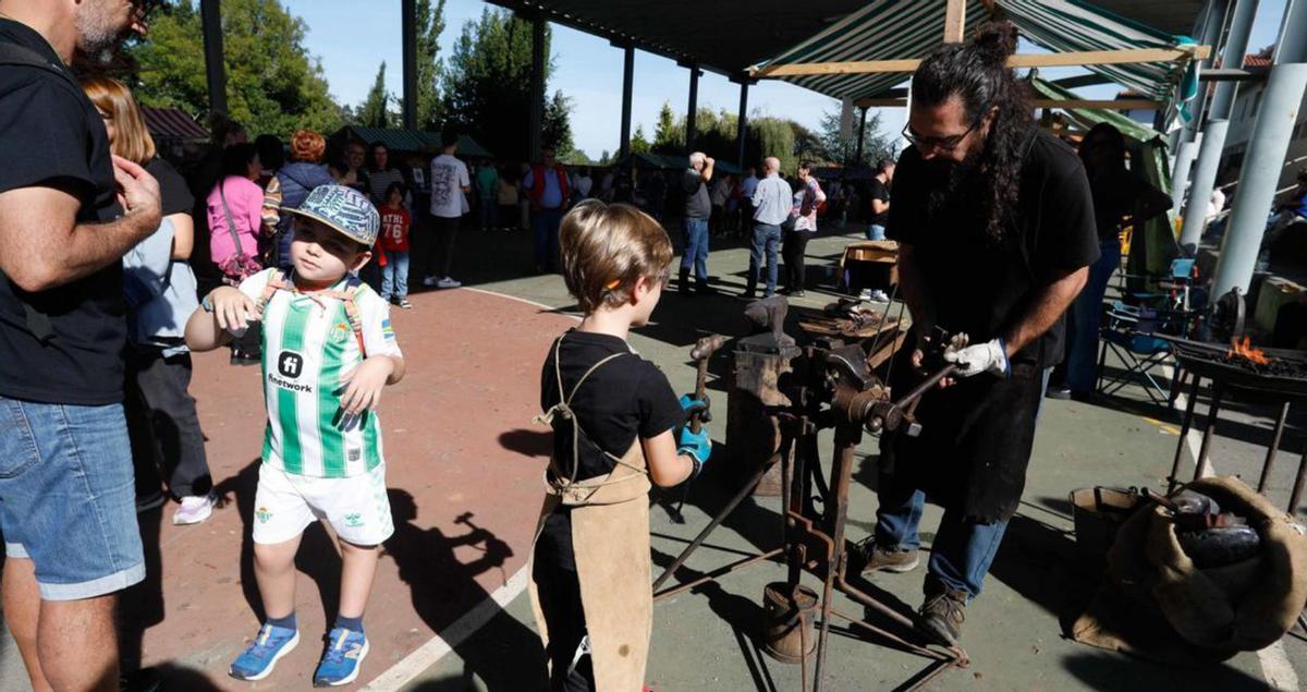 A la izquierda, un niño participa en uno de los talleres de artesanía. Junto a estas líneas, uno de los puestos en la fiesa de la Seronda. | M. Villamuza.