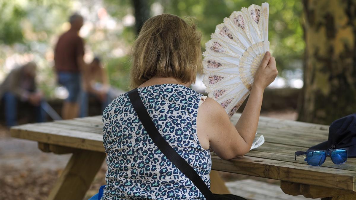 Una mujer se abanica en el parque del Rio Miño, en Lugo. EFE/ Eliseo Trigo