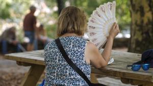 Una mujer se abanica en el parque del Rio Miño, en Lugo.