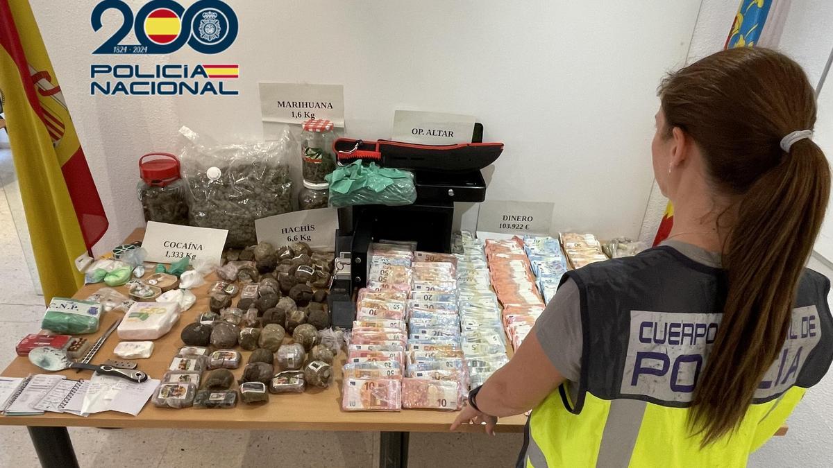 Una agente de la Policía Nacional posa ante las drogas y efectos intervenidos en Torrent.