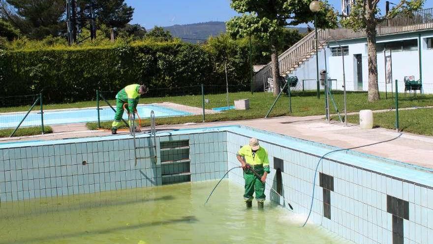 Operarios municipales limpian una de las piscinas de A Bandeira.