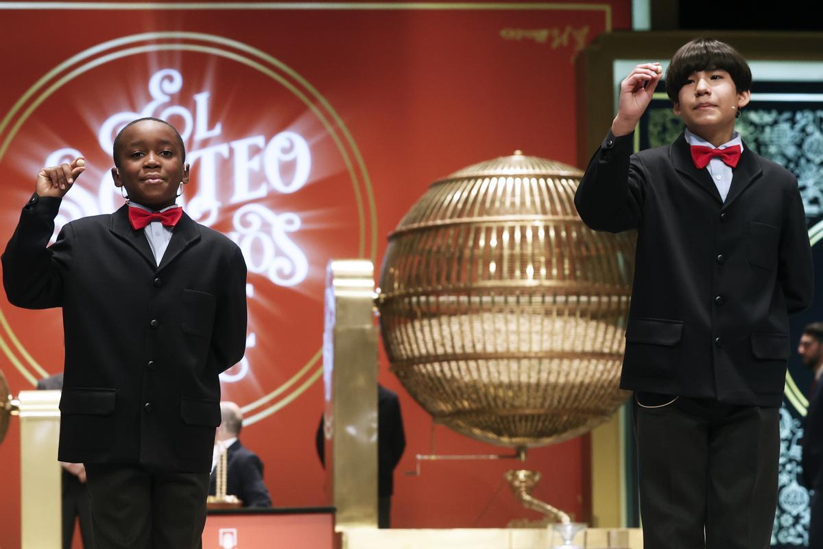 Los estudiantes de San Ildefonso Alonso Dávalos Durán (d) y Ángel Abaga Elebiyo (i) cantan el premio Gordo durante el sorteo de Navidad en el Teatro Real en Madrid, este jueves. EFE/ Javier Lizón