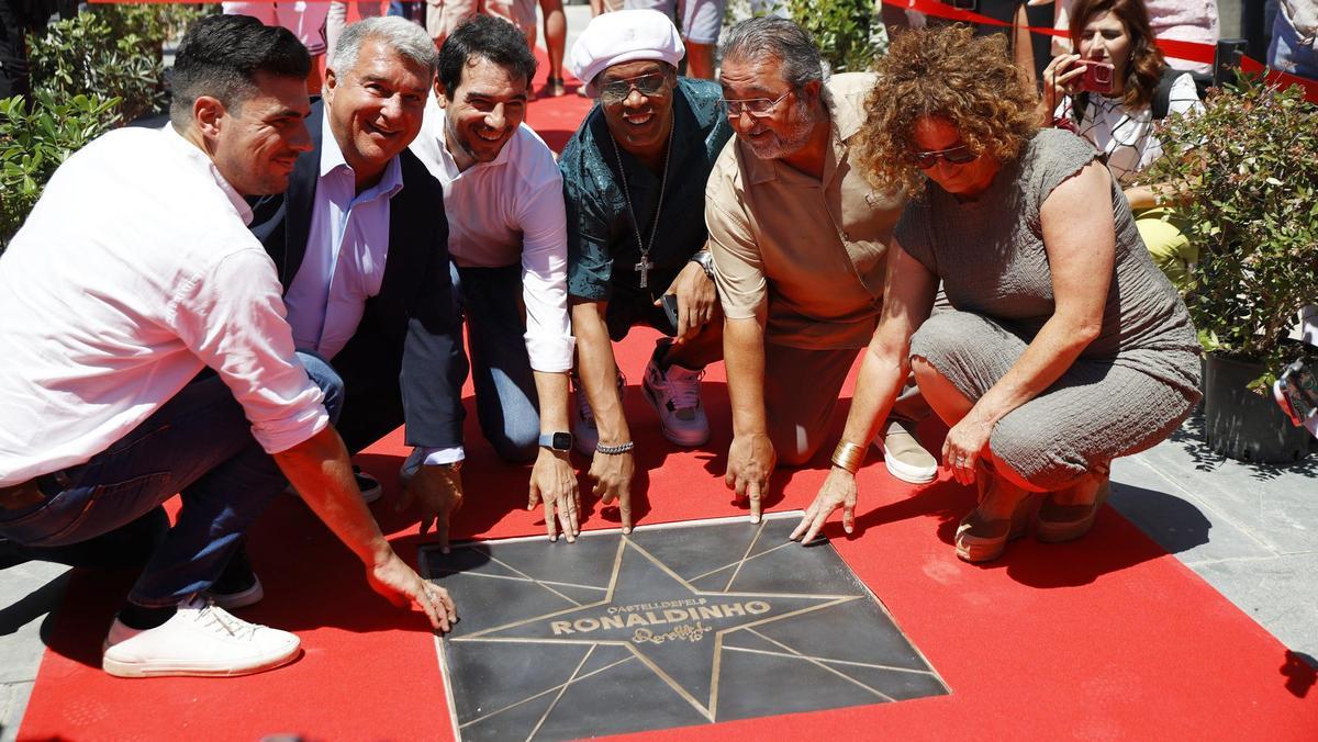 El presidente del FC Barcelona, Joan Laporta, el alcalde de Castelldefels, Manu Reyes, y el exfutbolista Ronaldinho posan junto a la Estrella de Ronaldinho durante la inauguración del Paseo de las Estrellas de Castelldefels, en la Plaza de las Palmeras, a 22 de junio de 2024, en Castelldefels, Barcelona, Catalunya