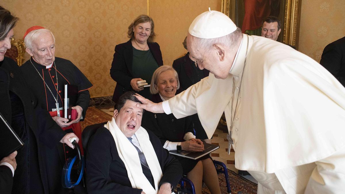 El Papa Francisco bendice al joven junto a su catequista.