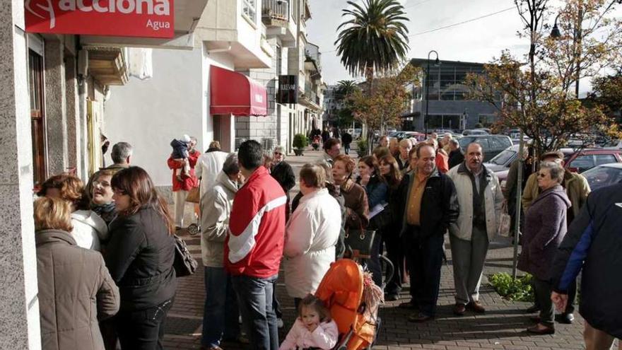 Decenas de vecinos hacen cola en la antigua sede de Acciona en Cangas, en imagen de archivo. // G.N.