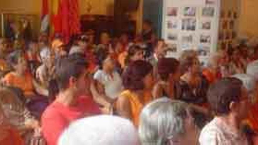 A la izquierda, los socios atienden la charla impartida en la sede de la colonia zamorana en Cuba. A la derecha, los participantes, ataviados con prendas de color naranja, en la marcha de protesta contra la violencia de género por las calles del casco histórico de La Habana.