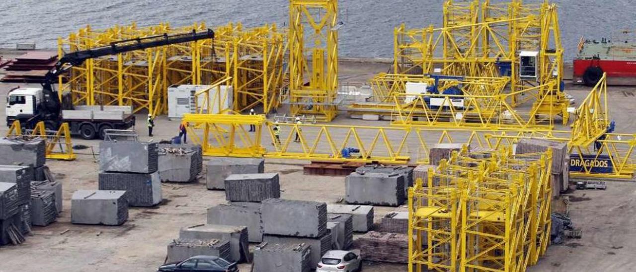 Camiones descargan materiales para las obras en el puente, ayer en el muelle de granito de Rande. // M. C.