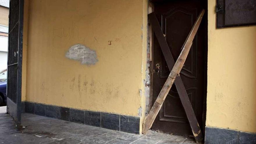 La puerta de la sede de la Federación de Asociación de Vecinos de Langreo, tras ser forzada.