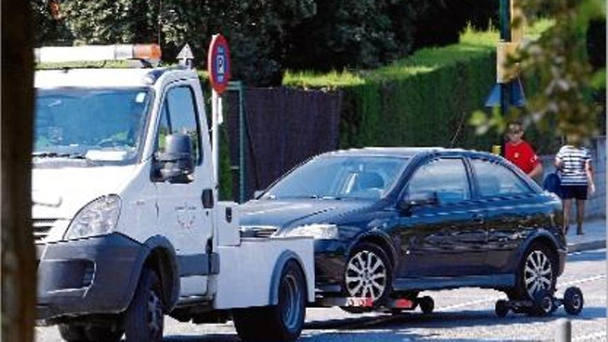 La grua de Girona enretirant un vehicle mal aparcat, en una imatge d&#039;arxiu.