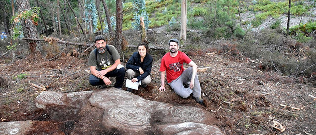 Membros de Capitán Gosende a carón do petróglifo do piñeiral da Guiela (Tenorio).