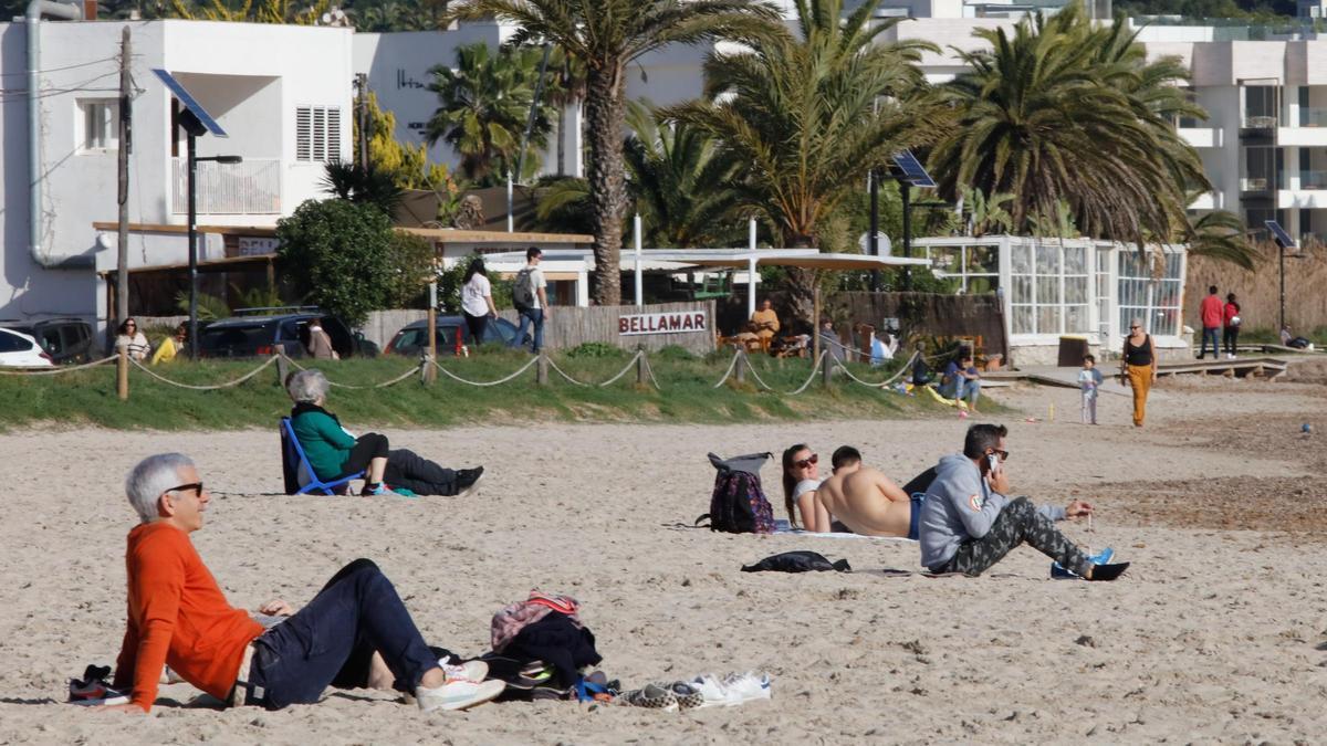Imagen de archivo de varias personas disfrutando del sol en la playa en otoño