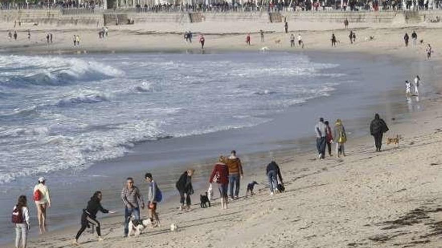 Paseantes en la playa de Samil, ayer. // Alba Villar