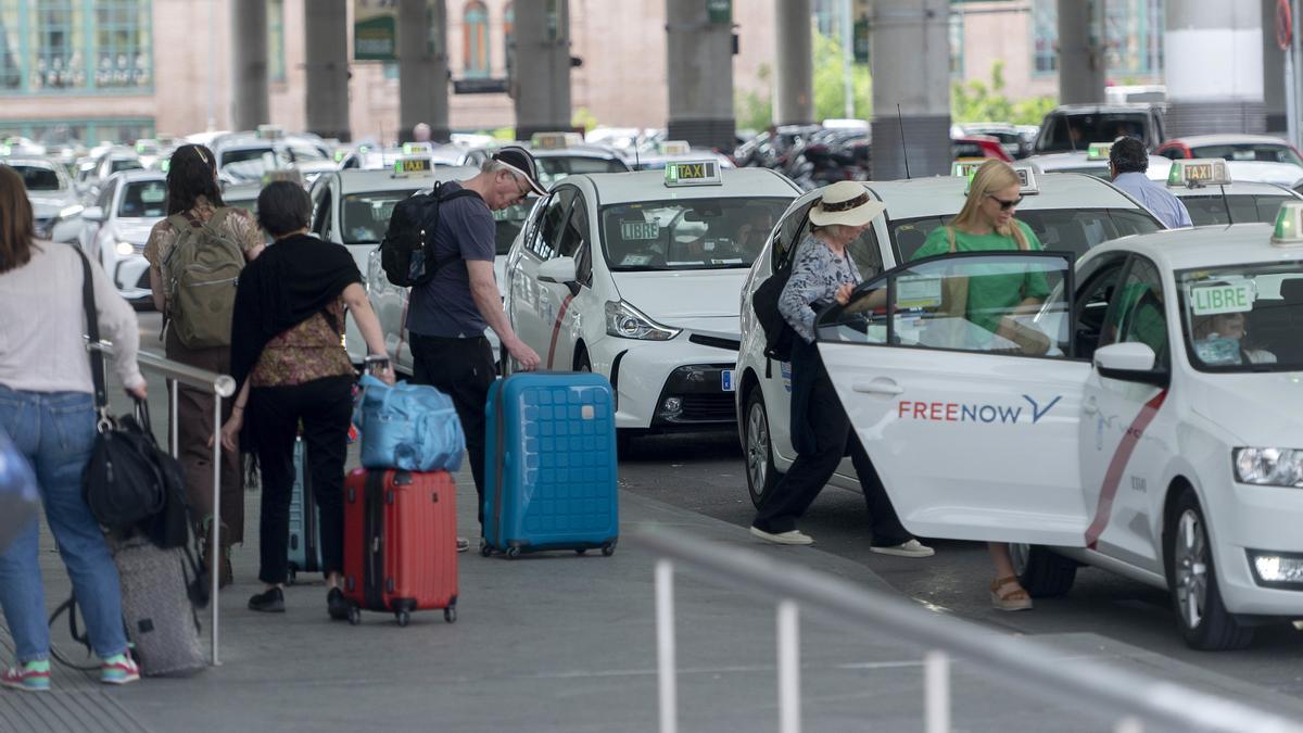Archivo - Varias personas con maletas esperan un taxi en la estación de Atocha-Almudena Grandes, a 2 de mayo de 2023, en Madrid (España)