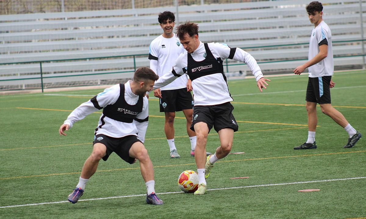 Isi Angulo y Carlos Segura luchan un balón en una sesión de trabajo de esta semana.