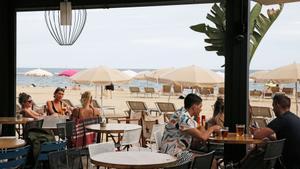 Turistas en un chiringuito de playa en Barcelona.