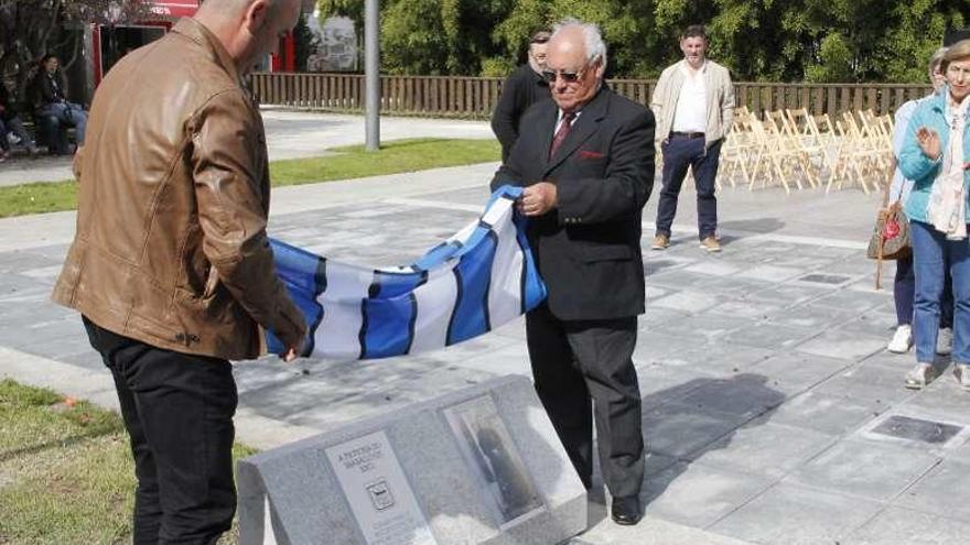 Félix Juncal y el bisnieto de María Mundín retiran la bandera de Bueu que cubría el monolito en homenaje a la mujer. // S.Álvarez