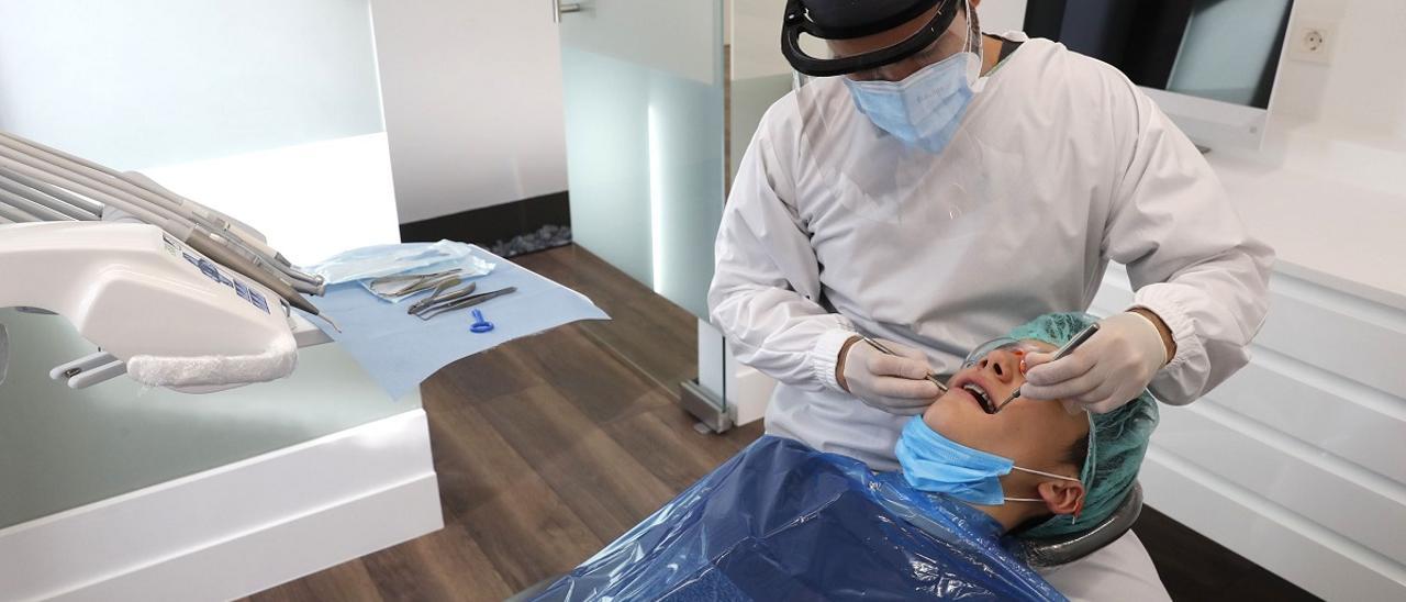 Un dentista atiende a una de sus pacientes en una clínica de Vigo