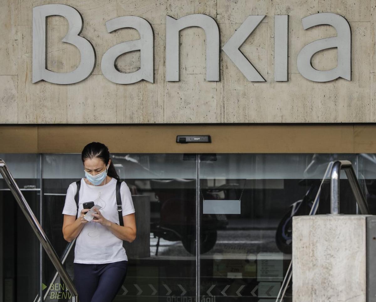 Una mujer sale de la sede de Bankia en Valencia.